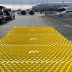 Reusable ground mat that traps dirt and mud at an airport.