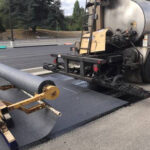 Installing paving geocomposites for asphalt repair