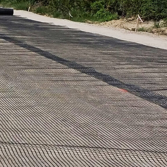 Large span of uniaxial geogrid across a slope for economical stabilization