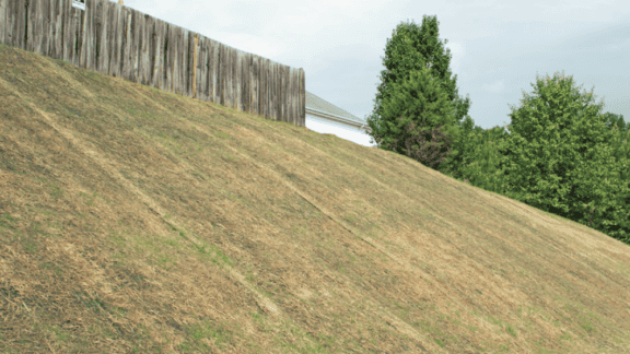 Geosynthetics protect hill from erosion, replacing timber wall.