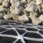 A composite geogrid providing separation between fill aggregate and soil for reliable stabilization