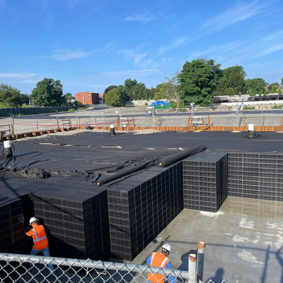 Installing R-Tank Stormwater System to manage runoff in a large area of impermeable cement.