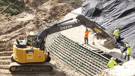 Installing a vegetated MSE retaining wall using GEOWEB to stabilize a slope.