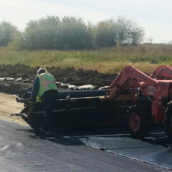 Installation of moisture-wicking geotextile on a raceway provides pavement alternative.