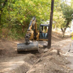 Removing debris before installing concrete canvas ditch lining.