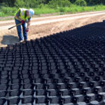 Construction professional using Atra® keys to secure GeoWeb geocell road repair system.