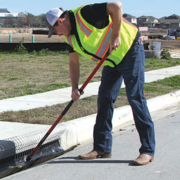 A construction worker removing a GeoCurve inlet filter for cleaning