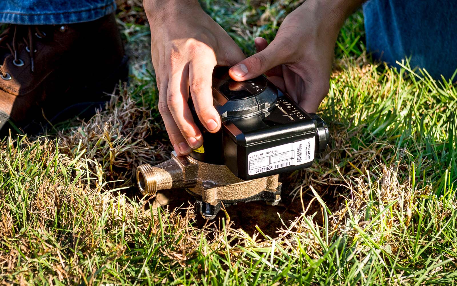 Closeup view of a water meter being installed in the ground.